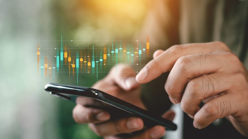 Businessmen,Investor,Think,Before,Buying,Stock,Market,Investment,Using,Smartphone Piețele financiare reacționează prudent la tensiunile din Orientul Mijlociu; analiștii anticipează volatilitate moderată, dar persistentă